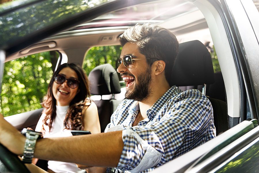 Contact - Closeup View of a Joyful Young Couple Having Fun Driving Together in a Car During a Road Trip on a Sunny Day